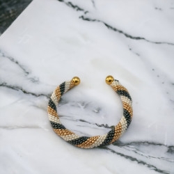 Met de hand gemaakte kralen armband gemonteerd op een gouden slavenarmband van messing