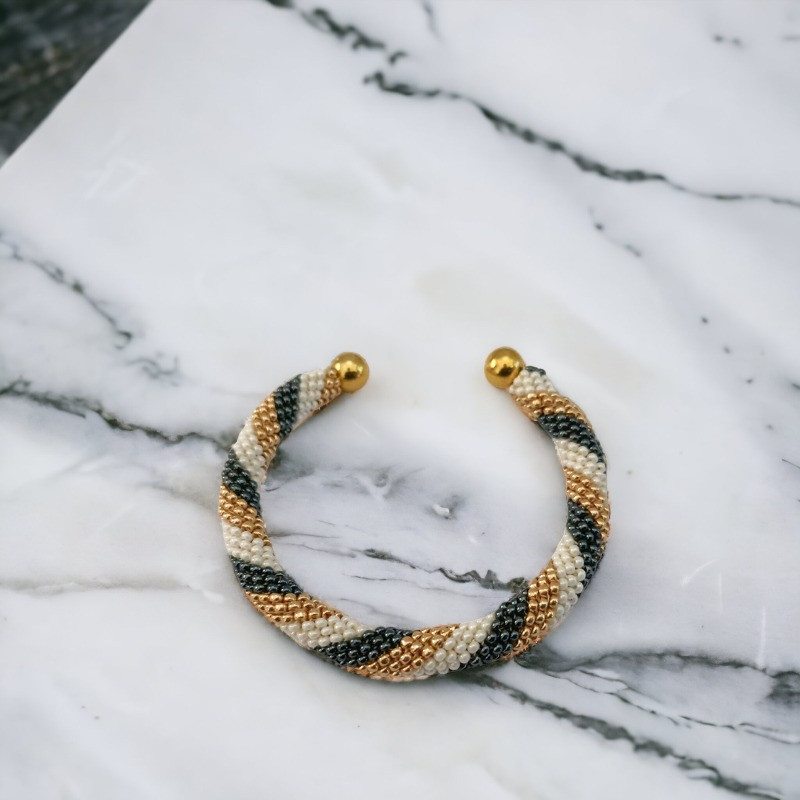 Met de hand gemaakte kralen armband gemonteerd op een gouden slavenarmband van messing